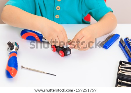 Little boy repairing toy train, early learning concept