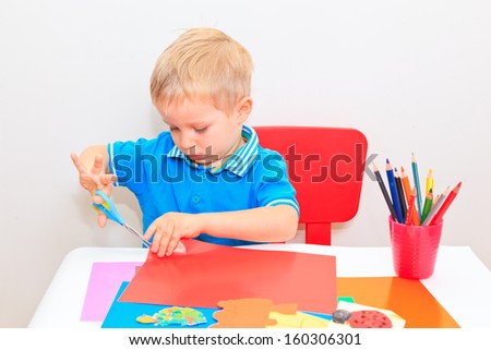 little boy cutting from paper, early learning and daycare concept