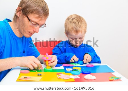 father and son playing with clay, early learning and daycare concept