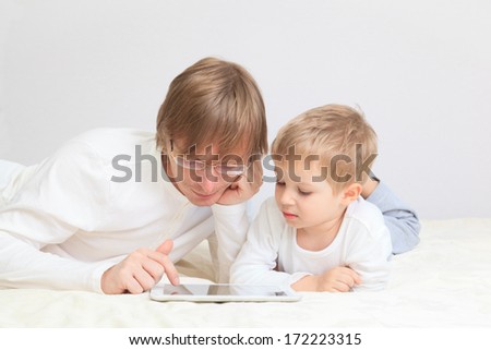 father and son with touch pad at home, family leisure