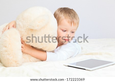 baby and teddy bear with touch pad at home, home comfort