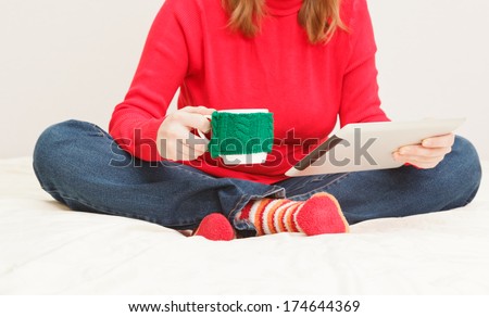 young woman with cup of coffee and tablet at home, home comfort