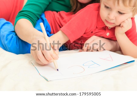 hands of mother and child writing letters, early education