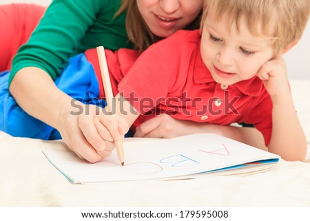 hands of mother and child writing letters, early education