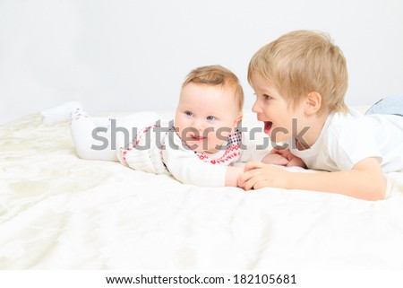 little boy talking to newborn sister, family communication