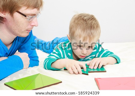 father and son playing with puzzle, early education concept