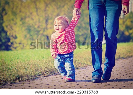 first steps of cute little girl in autumn park