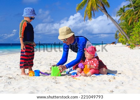 Father and kids making sand castle at tropical sand beach