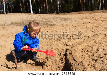 little boy digging sand in spring, kids activities