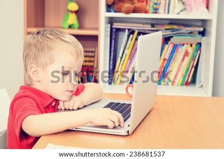 little boy working on laptop at home, early learning