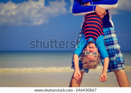 little boy having fun with dad on summer beach vacation