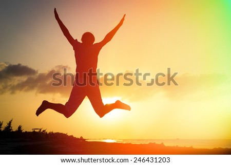 Silhouette of man jumping on sunset beach