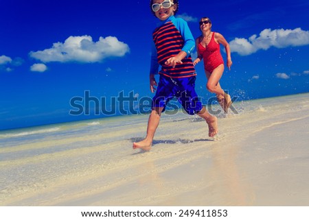 little boy and mother running on tropical beach