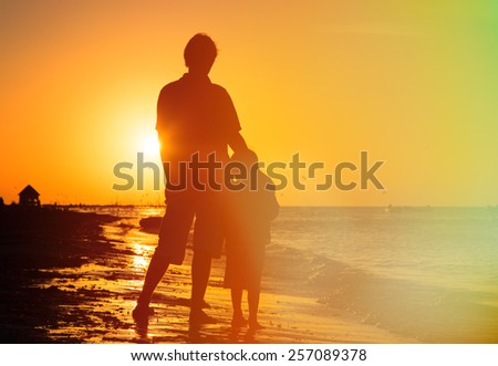 father and son hug at sunset beach