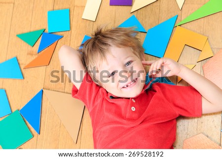 happy little boy with puzzle toys on wooden floor, early learning