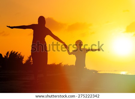 mother and son having fun on sunset beach