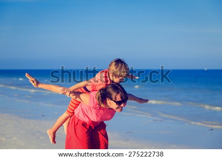 mother and son flying on the beach, family fun