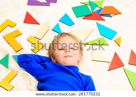happy little boy with puzzle toys on white, early learning