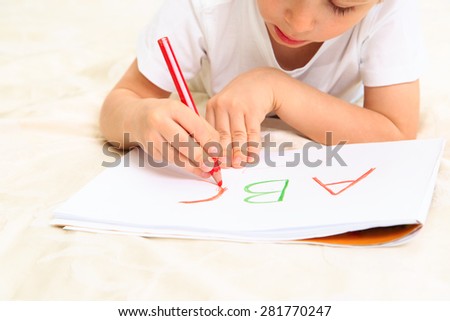 little boy learning to write letters, early education