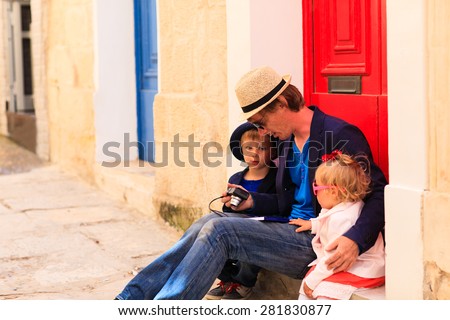 father and two kids looking camera on the street of Malta, family travel in Europe