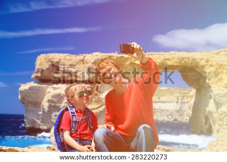 father and son making selfie photo against Azure Window on Gozo island, family travel
