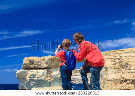 father and son making photo of Azure Window on Gozo island, family travel