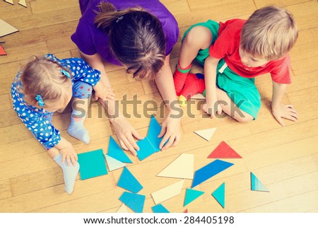 teacher and kids playing with geometric shapes, early learning