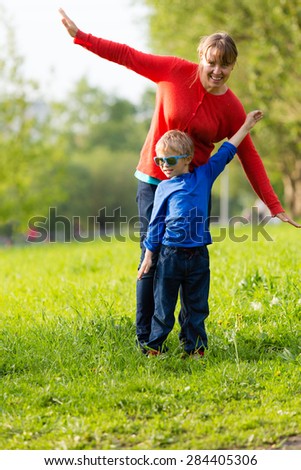 happy mother and son playing in summer park
