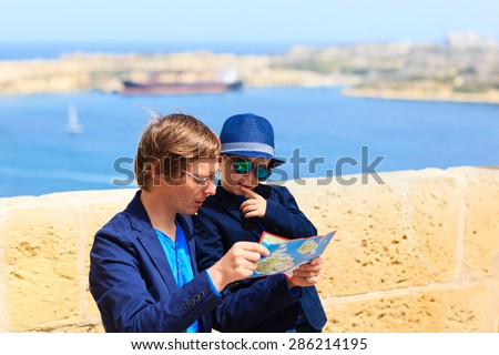 father and little son looking at map, family travel in Europe