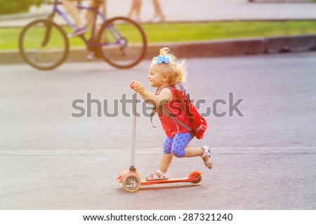cute little toddler girl riding scooter in the city, kids sport