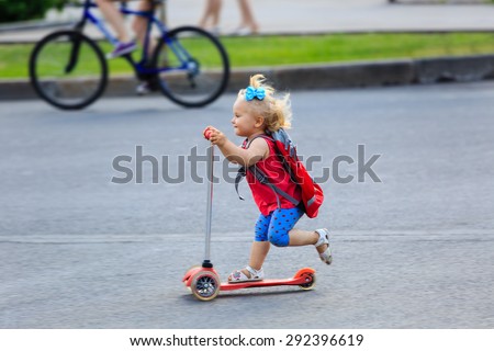 cute little toddler girl riding scooter in the city, kids sport