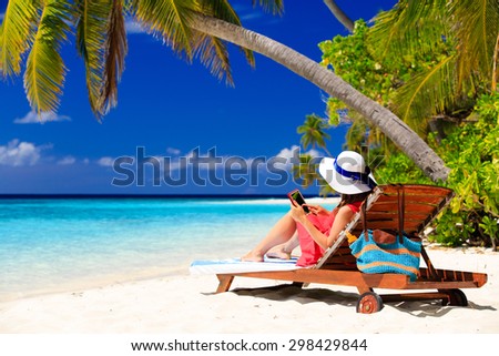 woman with touch pad on tropical beach vacation