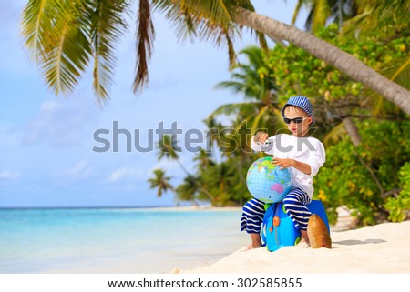 little boy travel on summer tropical beach with globe and toy plane