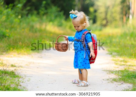 cute little girl picking mushrooms in summer forest, kids summer outdoor activities