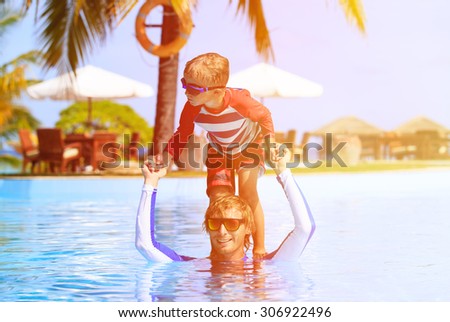 father and son having fun in swimming pool, family vacation
