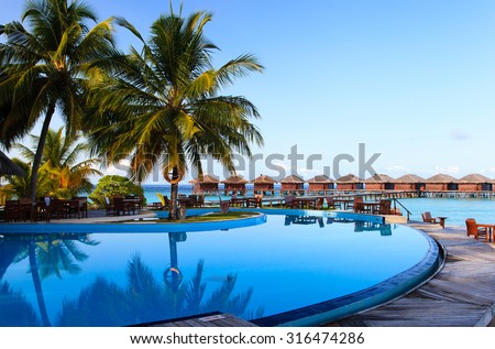 Tropical resort swimming pool and cafe bar near the beach