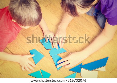 hands of teacher and child playing with geometric shapes, early learning