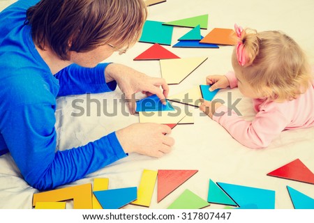 teacher and child playing with geometric shapes, early learning