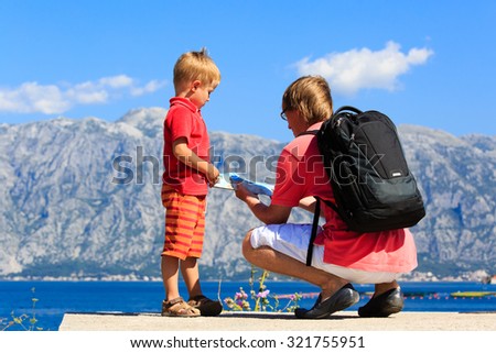 father and son looking at map travel in mountains, family travel