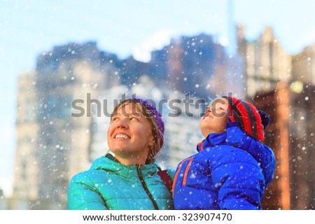 mother and son enjoy first snow, family winter in the city