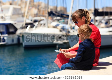 mother and son looking at map in the port, family travel