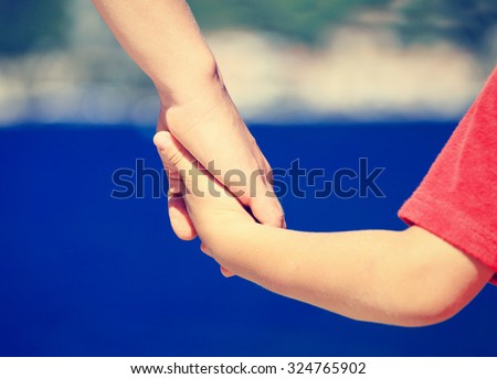 mother and son holding hands on sea vacation, family travel