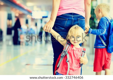 mother and two kids walking in the airport, family travel