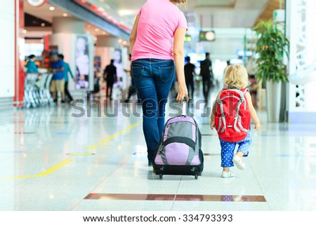 mother and little daughter walking in the airport, family travel