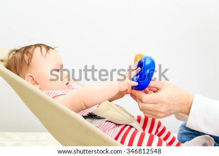 little girl learning to play first toys with parent, early learning
