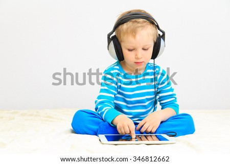 little boy with headset using touch pad, early education and learning