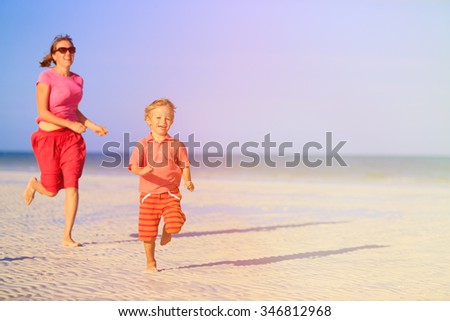 happy little boy with mother running on summer beach
