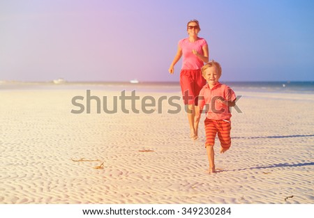 happy little boy with mother running on summer beach