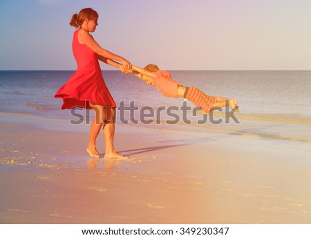 mother and son playing on summer tropical beach