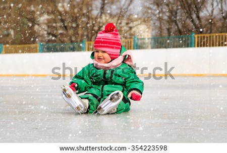 cute little girl sitting on ice with skates, kids sport